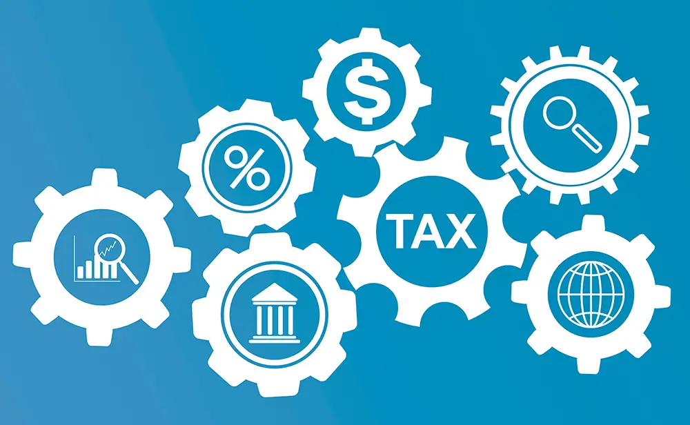 A graphic showcasing several interlocking gears, with the central gear labeled "Tax." Other gears display icons like a dollar sign, magnifying glass, percentage symbol, and bank building. The background is blue. This visual represents Alliott Peirson International's comprehensive approach to global tax advisory services.
