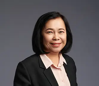 A Picture of woman employee standing in front of grey background wall.